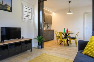 een woonkamer met een tv en een tafel met stoelen bij Sapiti Modern by Mmega in Florence