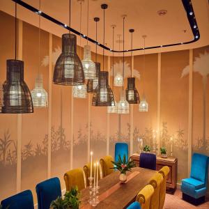 a dining room with a table and chairs and chandeliers at The Drayton Hotel Savannah, Curio Collection by Hilton in Savannah