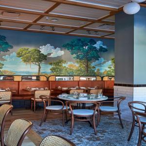 a dining room with tables and chairs and a mural at The Drayton Hotel Savannah, Curio Collection by Hilton in Savannah
