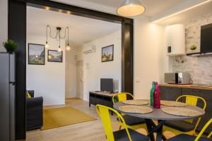 een keuken en eetkamer met een tafel en gele stoelen bij Sapiti Modern by Mmega in Florence