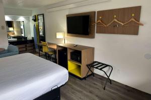 una camera d'albergo con letto e scrivania con TV di Days Inn by Wyndham Columbus Worthington a Columbus