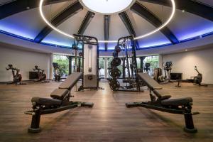 einen Fitnessraum mit Laufbändern und einem großen Spiegel in der Unterkunft DoubleTree by Hilton Berlin Ku'damm in Berlin
