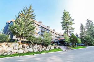 a road in front of a building with trees and rocks at Hilton Vacation Club Tahoe Seasons Lake Tahoe in South Lake Tahoe