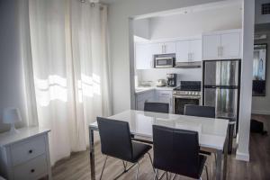 a white kitchen with a white table and chairs at 12th & Ocean by LuxUrban, Trademark Collection by Wyndham in Miami Beach