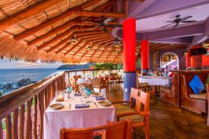 a restaurant with tables and chairs and the ocean at Hilton Grand Vacations Club Zihuatanejo in Zihuatanejo