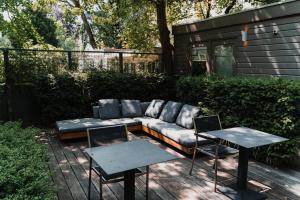 a couch and two tables on a patio at Hotel Roemer Amsterdam in Amsterdam