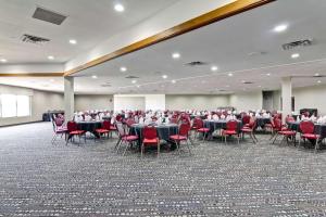 a large banquet hall with tables and red chairs at Radisson Hotel & Conference Centre West Edmonton in Edmonton
