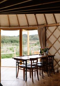 a dining room with a table and chairs in a yurt at Tree Field Yurt at Moor Farm in Godshill