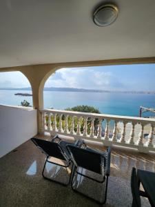 una silla en el balcón con vistas al océano en Lucija en Karlobag
