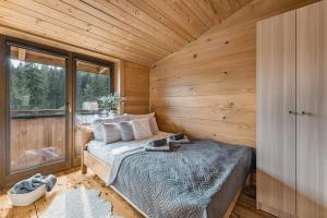 a bedroom with a bed in a wooden cabin at Domek w Halpusie in Łapsze Niżne