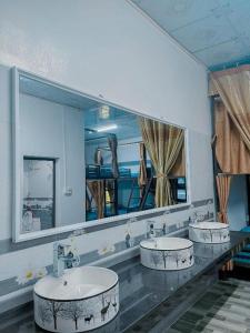 a bathroom with two sinks and a large mirror at Hoang Phuc Hotel Cat Ba in Cat Ba