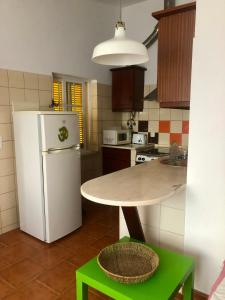 ナザレにあるAvó das Bolachas - Home Shantiのキッチン(白い冷蔵庫、テーブル付)