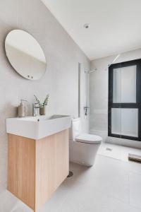 La salle de bains est pourvue d'un lavabo, de toilettes et d'un miroir. dans l'établissement Home2Book Panoramic Views & Stylish Design Agaete, à Agaete