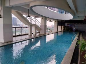 a large swimming pool in a building at Daima Suites Margonda in Perhentian Pondoktjina
