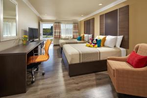 Habitación de hotel con 2 camas y escritorio en Eden Roc Inn & Suites near the Maingate, en Anaheim