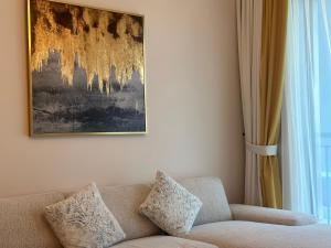 a living room with a couch and a painting on the wall at ROYAL APARTMENTS DUBAI in Dubai