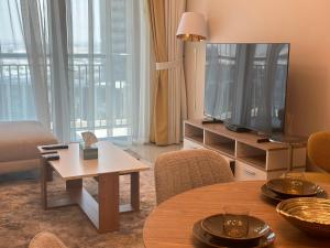sala de estar con TV y mesa en ROYAL APARTMENTS DUBAI en Dubái
