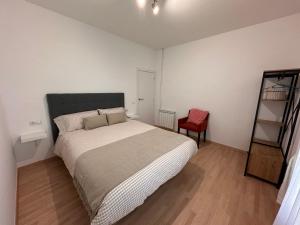 a bedroom with a large bed and a red chair at Ruta del ferro in Ripoll +14 photos