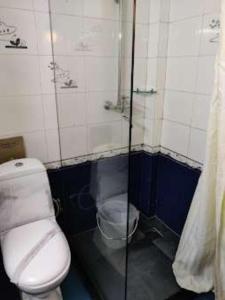 a small bathroom with a toilet and a shower at Darjeeling La Resort in Darjeeling