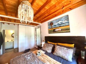 a living room with a couch and a chandelier at Critchely Stone Villa, Dullstroom in Dullstroom