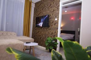 a living room with a couch and a tv on a wall at Artsy Urban 1Br along Kiambu Road with a pool and scenic views in Kiambu
