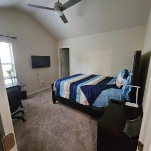 1 dormitorio con cama, escritorio y ventilador de techo en Elizabeth Experiences, en Atlanta