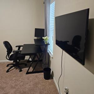 a room with a television and a desk with chairs at Elizabeth Experiences in Atlanta