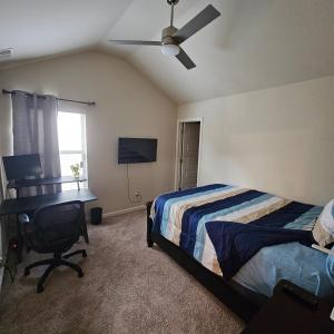 1 dormitorio con cama, escritorio y ventilador de techo en Elizabeth Experiences, en Atlanta