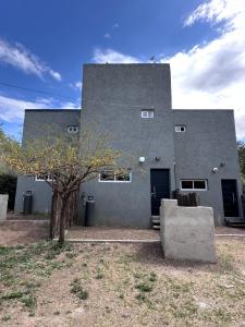 サンタ・ロサ・デ・カラムチタにあるAromas del Valleの木の目の前の灰色の建物