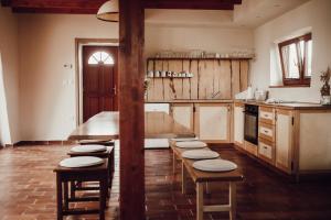 a kitchen with wooden tables and chairs in it at Ecological farm Makrobios Panonija in Gornji Petrovci