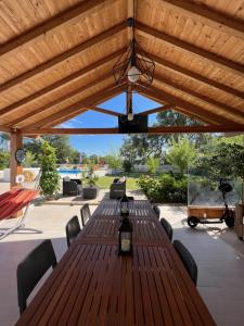 a patio with wooden tables and chairs under a wooden pergola at Casa do Cedro no Campo in Correias