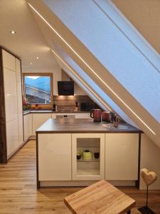 an attic kitchen with a counter top under a roof at Ferienwohnung HELISA in Hart im Zillertal