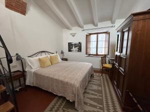 Schlafzimmer mit einem Bett und einem Fenster in der Unterkunft B&B Borgolecchi , Lecchi in Chianti in San Sano