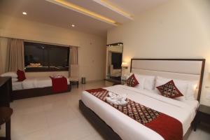 a hotel room with two beds and a large window at Hotel Indira Nikunj in Rishīkesh