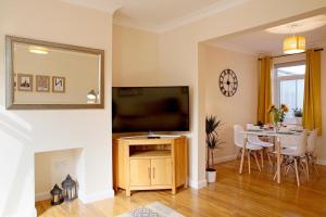 uma sala de estar com televisão e uma mesa com cadeiras em Central Norwich House W Parking Ginger&gold em Norwich