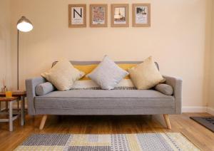 un salon avec un canapé gris avec des oreillers dans l'établissement 2br Stylish Norwich Stay Near Cathedral Parking, à Norwich 18 autres photos