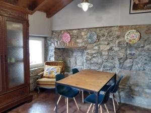 comedor con mesa de madera y sillas azules en Charming attic apartment with terrace next to Bellagio HORTA' en Lezzeno