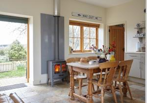 a kitchen with a table and a wood stove at The Grainstore at Moor Farm in Godshill