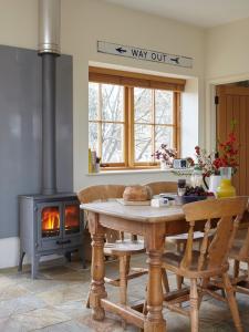 a kitchen with a table and a wood stove at The Grainstore at Moor Farm in Godshill