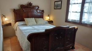 a bedroom with a large bed with a wooden headboard at La Calma Montblanc Prenafeta in Prenafeta