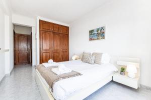 Dormitorio blanco con cama grande y puerta de madera en Lagos Sea View by Algarve Golden Properties, en Lagos