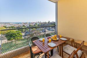 balcón con mesa de madera y sillas con vistas en Lagos Sea View by Algarve Golden Properties en Lagos