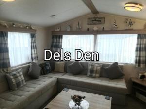a living room with a couch and a table at Del's den lakeside weeley bridge in Weeley