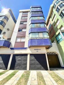 un edificio alto con paneles solares. en Apto a 20 metros da praia, en Capão da Canoa