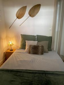 een bed met twee parasols aan de muur bij Narbonne : Logement idéalement situé in Narbonne