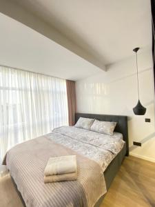 1 dormitorio con 1 cama con 2 toallas en Cozy Central Apartment Lev Tolstoi 43b, en Chişinău