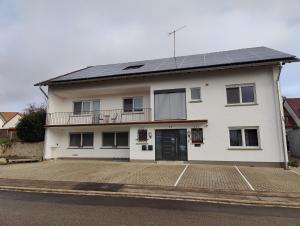 a white house with solar panels on the roof at Carina Apartment in Kandern