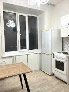 a kitchen with white appliances and a wooden table at Very central location 2 room (+kitchen toom) in Ulaanbaatar