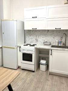 a white kitchen with a stove and a refrigerator at Very central location 2 room (+kitchen toom) in Ulaanbaatar