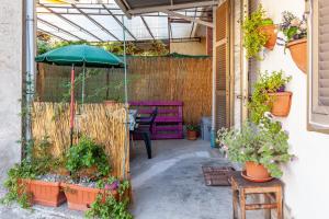 un patio con tavolo, ombrellone e piante di Il borgo al mare a Massa